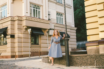 woman walking in dress in old city. Fashion Style Photo Of A Young Girl. happy stylish woman at old european city street. Tourist background of hotel. Man near building facade old european hotel