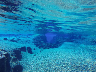 Fototapeta na wymiar Unterwasser Szene mit klaren, blauen Wasser, Felsen und Sand