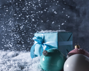 christmas balls and gift box on blue snow background