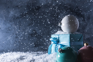 christmas balls and gift box on blue snow background