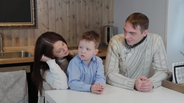 Happy family with a child in the kitchen in a modern interior.