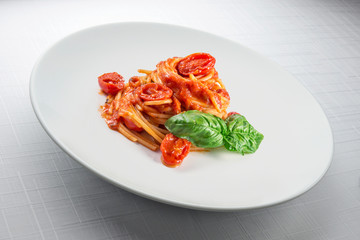 Elegant White round plate with spaghetti tomato and basil