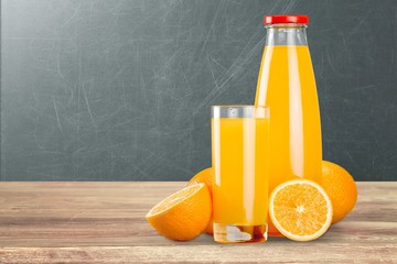 Orange juice and slices of orange on a school blackboard background - obrazy, fototapety, plakaty