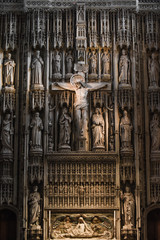 Jesus Christ on the cross in a cathedral or church interior surrounded by ornate stone carvings