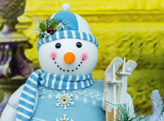 Christmas snowman toy in a blue sweater, scarf and hat.