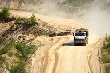 Obraz na płótnie Canvas Dump truck transports sand and other minerals in the mining quarry.