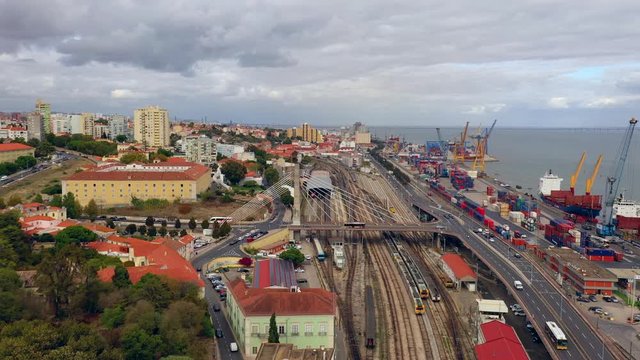 Aerial, pan, drone shot, of the railway, the harbor, the Convent Santos-O-Novo and the Igreja Paroquial de Santa Engracia and the cityscape of Lisbon, Portugal