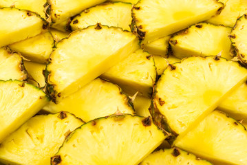 Pineapple juicy yellow slices background. Top view.