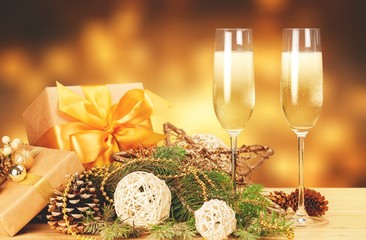 Two celebration glasses of Champagne with Christmass stuff on warm background