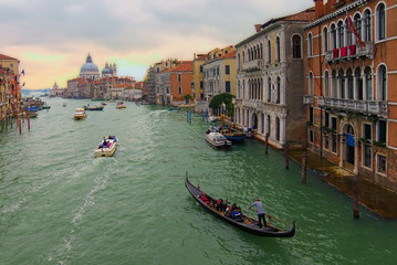 Fototapeta na wymiar Picturesque landscape of Grand Canal with turquoise water. Medieval colorful buildings and palazzo along the canal. Basilica Santa Maria della Salute in the background. Travel and tourism concept