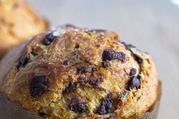 Close-up of panettone with chocolate chips on wooden background out of focus horizontally