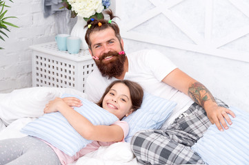 Obraz na płótnie Canvas i love my daddy. happy morning together. funny pajama party. small girl with bearded father in bed. weekend at home. father and daughter having fun. family bonding time. dad and kid relax in bedroom