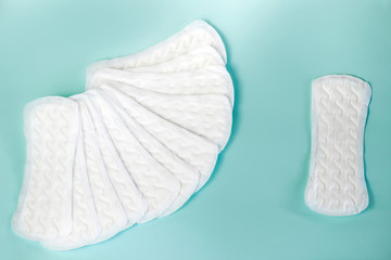 flat lay of feminine hygiene items. Details for critical women's days on a turquoise background. Gaskets for women, health