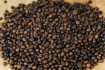 a lot of coffee beans on a wooden background. background and space for text