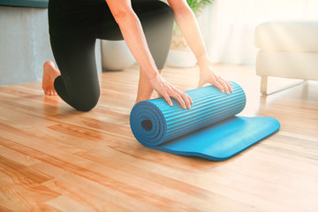 Close mat woman enjoying yoga indoors in the living room