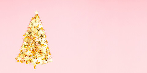 Christmas minimal composition. Christmas tree made of gold confetti on pastel pink background....