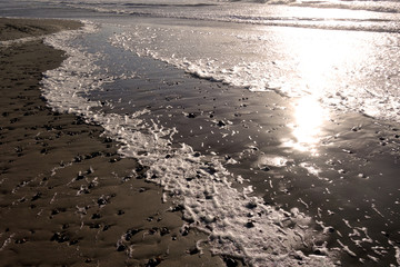 Reflexion der Sonnenstrahlen im Wasser am Strand