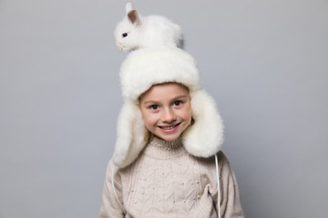 happy little girl with adorable rabbit at christmas time.