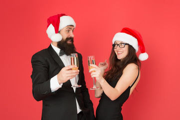 Lets have fun. Office party. Winter party. Merry christmas. Couple at corporate party. Happy new year. Bearded businessman in tuxedo and girl elegant dress drinking sparkling wine red background