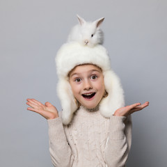 happy little girl with adorable rabbit at christmas time.