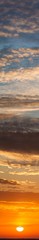 Fototapeta na wymiar Fantastic clouds at sunrise, vertical panorama