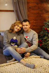 husband and wife in bed next to a christmas tree