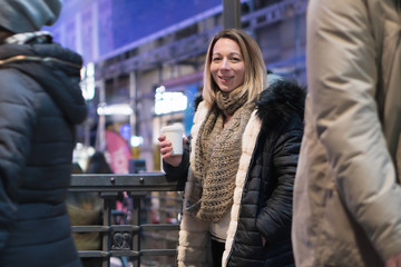 Woman with coffee on the street. Beautiful fashionable young woman with coffee in night city .