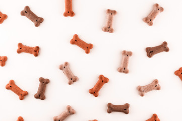 Dog food pattern made with dry snacks in shape of bones. Funny cute flat lay texture. Home pets, animals feeding. Special diet, training supply.
