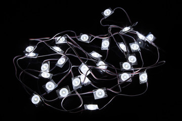 Cold white led christmas holiday lights modules on black background.