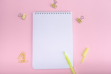 spring notebook, pen and stationery on a pink female-style desktop, top view. Kandy color style.