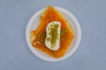 Middle-Eastern Delicious traditional dessert kadayif kunefe with pistachios. Ice cream on top. Turkish dessert kadayif kunefe.