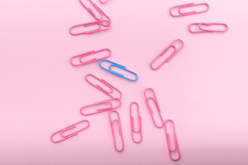 background with paper clips on a pink background. A blue paper clip and many pinks nearby. Concept on the topic: you are special