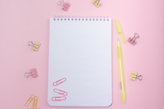 spring notebook, pen and stationery on a pink female-style desktop, top view. Kandy color style.