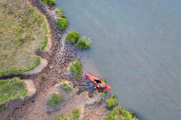 kayaker on a muddy shore of Dismal River