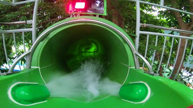 excited kid sliding the waterslide at indoor aquapark