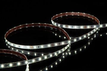 Cold white LED strip on black background.