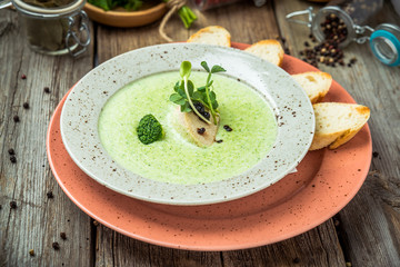 Spinach cream soup in bowl on white rustic table, top view