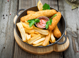 Fish and Chips on wooden table, tasty food.