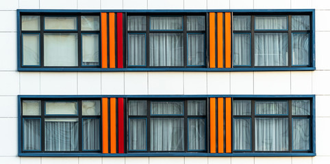 Modern bright facade of a kindergarten. Texture of wall with windows of a public building. Positive vibrant architecture.