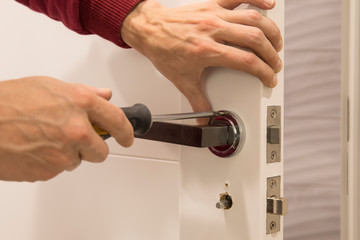 carpenter Installing the lock on the door Installation of the door lock.