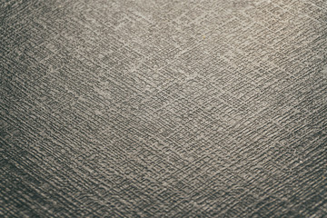 Close-up of customer grade realistic black plastic high detail textured leather imitation flat surface background in partial focus with high contrast abstract light reflections