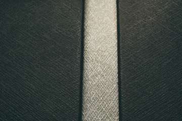 Fototapeta premium Close-up of customer grade realistic black and white plastic high detail textured leather imitation background surface with vertical line segment