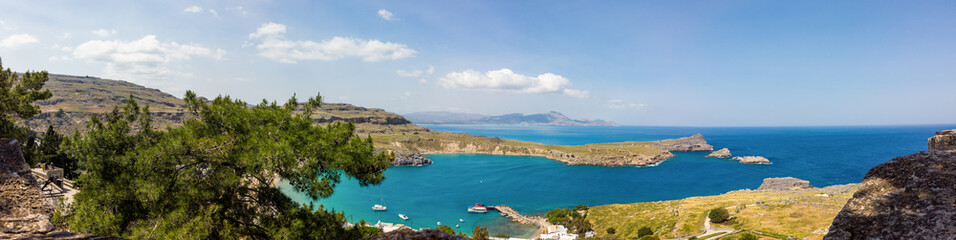 Fototapeta na wymiar A blue sea and mountains in sunny summer day. St Paul's Bay in Rhodes Greece Europe.