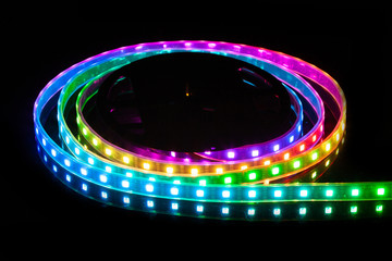 RGB LED strip on reel with black background.