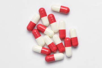 medicine in cylindrical capsules of red color on a white background