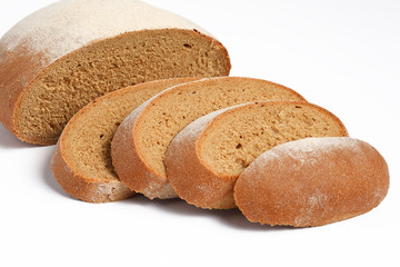 Loaf of fresh bread partially sliced on white background