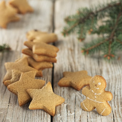 Christmas homemade gingerbread cookies, gingerbread man. On a wooden vintage background, near the branches of spruce. Close-up.