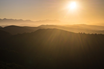 Montañas a contraluz en un atardecer soleado en la cima del Parque natural Saja, Cantabria