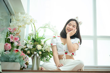 A beautiful Asian woman is cute, bright and she is with beautiful flowers on the weekends.