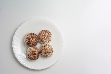 Marshmallows with chocolate on a white plate. Copy space. Sweet background.